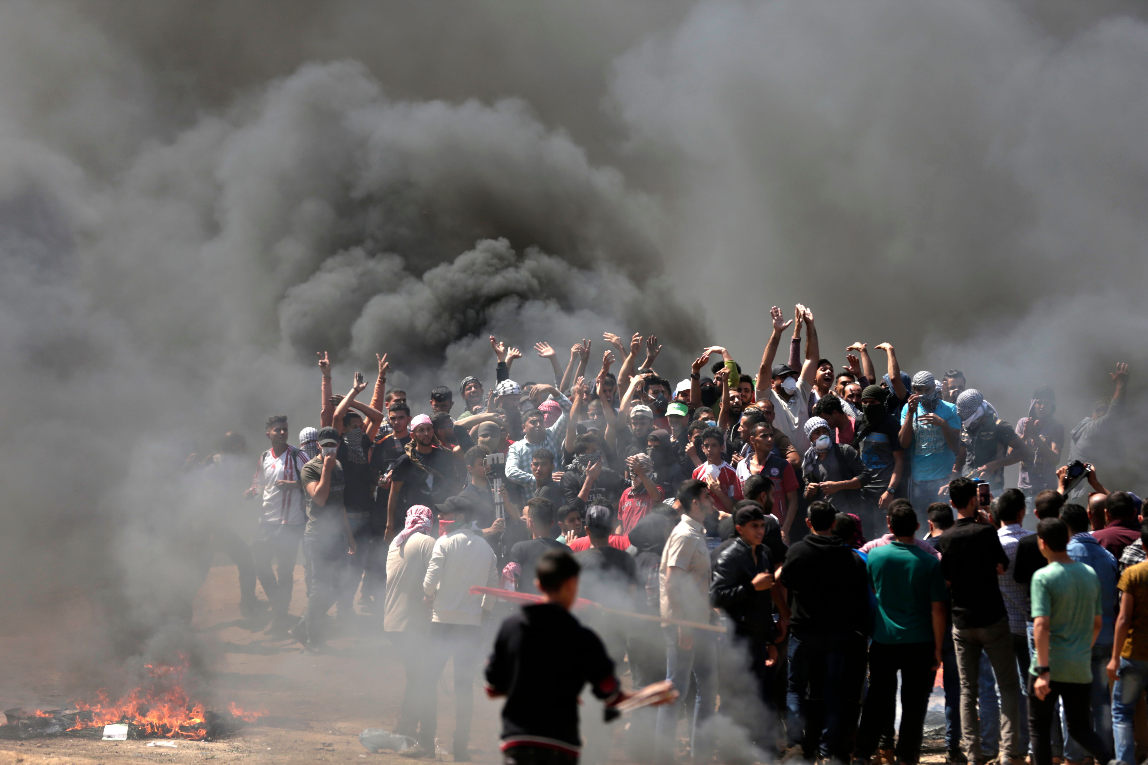 Palestinian demonstrators burn tyres near the Gaza-Israel border, east of Gaza City, as Palestinians readied for protests over the inauguration of the US embassy following its controversial move to Jerusalem on July 14, 0218.  / AFP PHOTO / MAHMUD HAMS