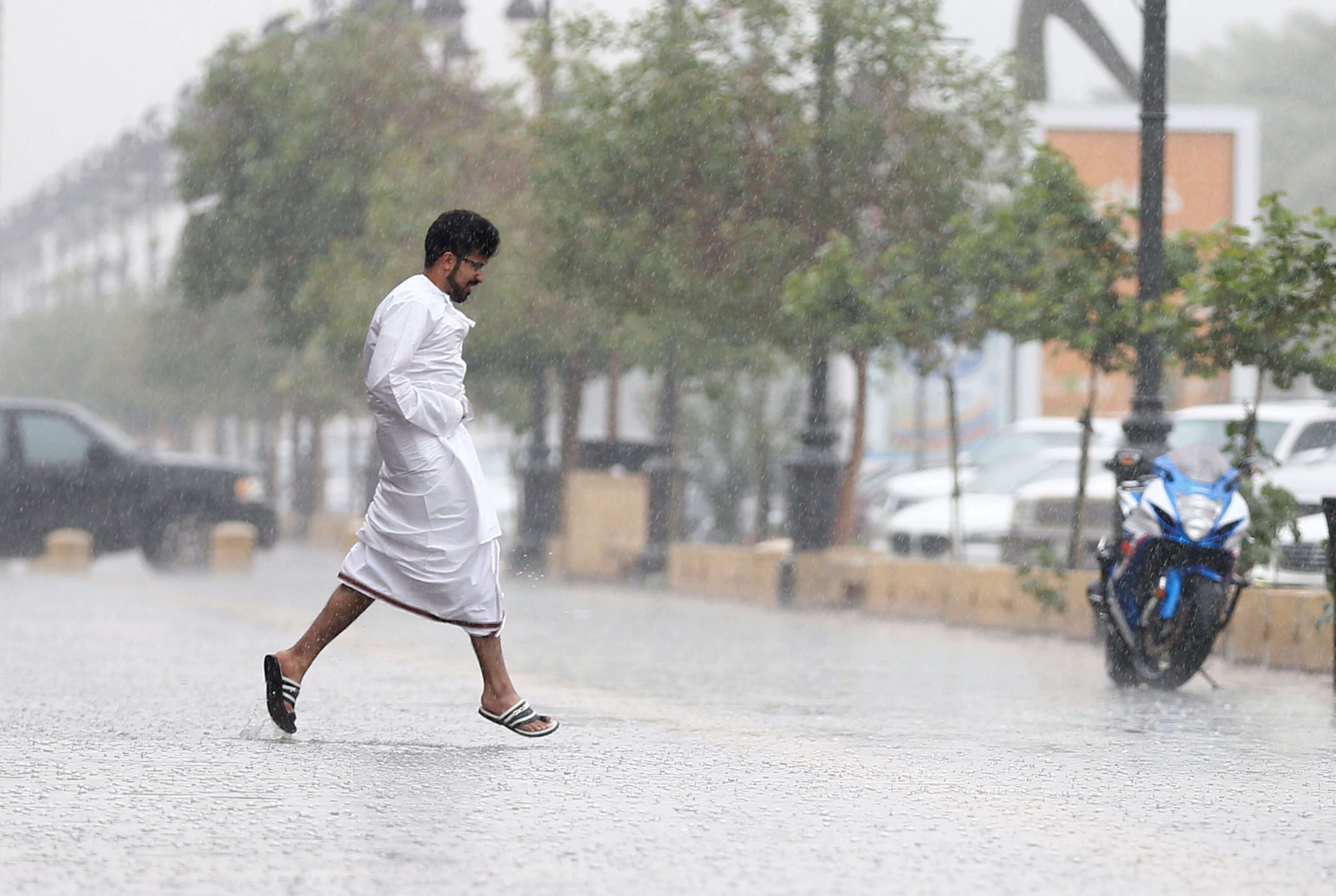 A man runs for cover during rain in Riyadh, Saudi Arabia, February 16, 2017. REUTERS/Faisal Al Nasser